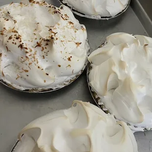 four pies with white frosting