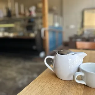 a coffee pot and a cup on a table