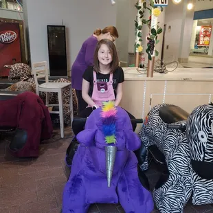 Birthday girl on her rainbow unicorn.