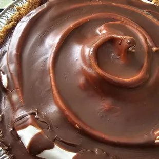 a chocolate pie with whipped cream and chocolate icing