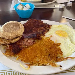 Corned beef hash, over medium eggs, english muffin, and hash browns