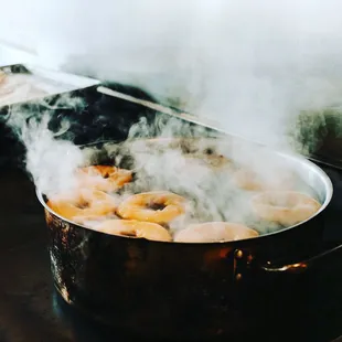 a steaming pot of bagels