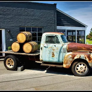 an old truck with barrels on the back