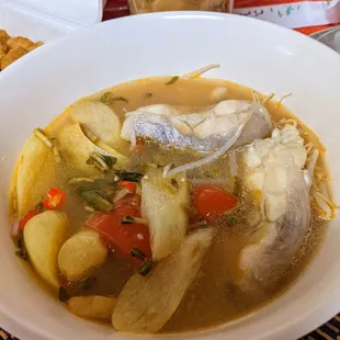 a bowl of soup with fish and vegetables