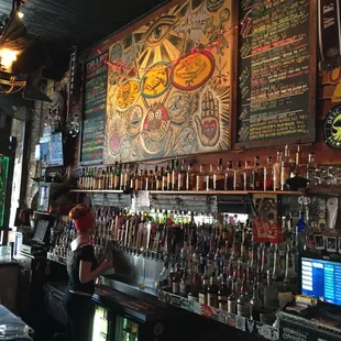 Behind the bar. Lots of craft brews.