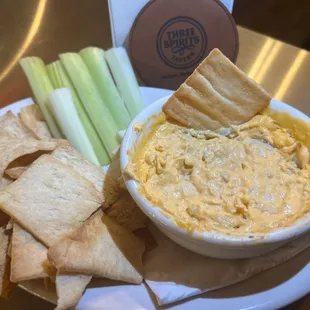 Buffalo chicken dip with blue cheese crumbles, celery and pita.