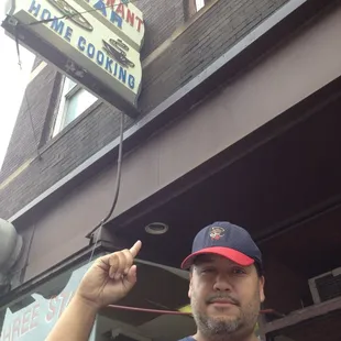 a man pointing at the sign