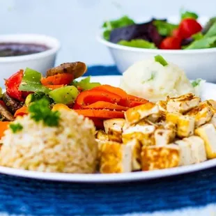 a plate of chicken, rice, and vegetables