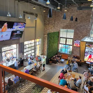 people sitting at tables and watching televisions