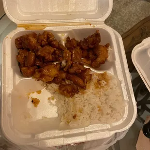 a takeout box with rice and meat