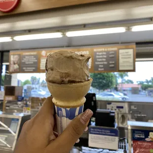 a hand holding an ice cream cone