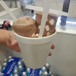 a person holding a cup of ice cream