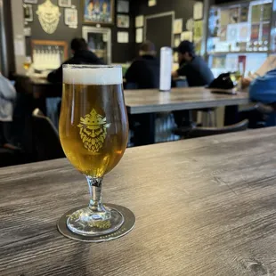 a glass of beer on a bar