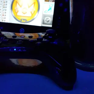 a video game controller next to a glass of water