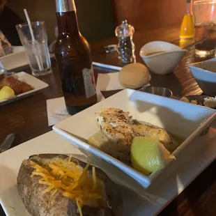 a plate of baked potatoes and a bottle of beer