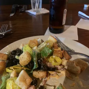 a plate of salad and a bottle of beer