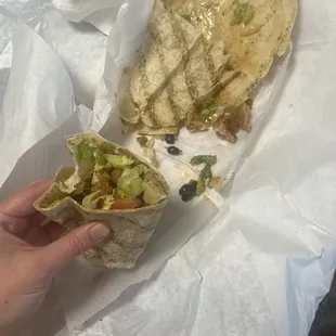 a hand holding a burrito