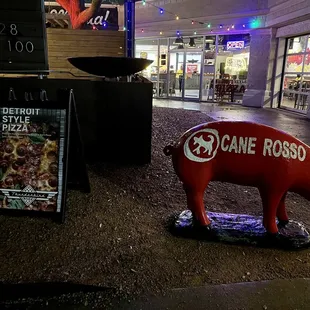 a pig statue in front of a store