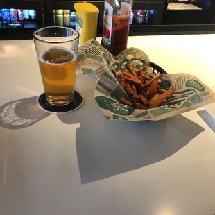 a tray of fries and a glass of beer