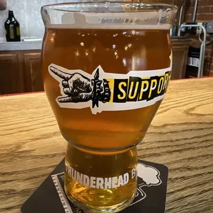 a glass of beer on a coaster