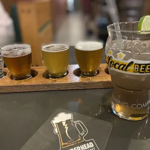 a flight of beer glasses and a coaster