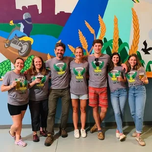 a group of people standing in front of a mural