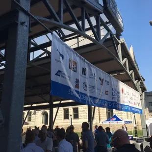 a crowd of people standing under a canopy