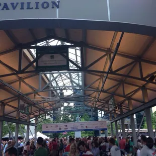 a crowd of people walking under a pavilion