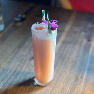 a tall glass with a flower garnish