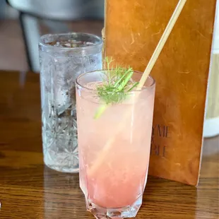 a pink drink with a straw in a glass