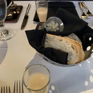 An amuse bouche with bread and flavored butter. Elegant white table cloth service.