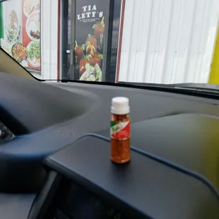 a bottle of ketchup on the dashboard of a car