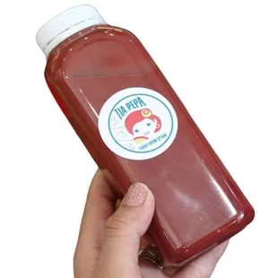 a hand holding a bottle of ketchup
