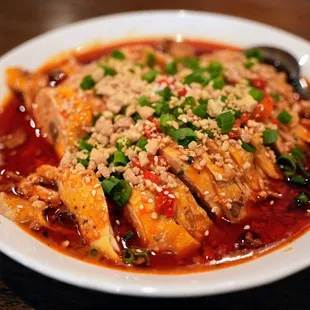 Mouthwatering Chicken (重庆口水鸡): chicken leg quarters, topped with roasted peanuts, scallions, sesame seeds, sesame-peanut sauce ($16.99).