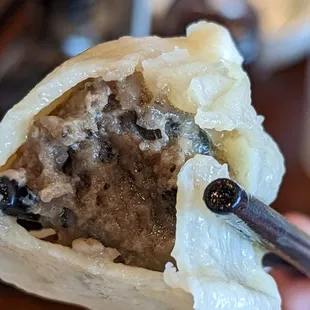 black truffle xiao long bao - visibly darker filling than in shanghai xiao long bao