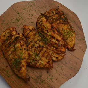 two pieces of chicken on a cutting board