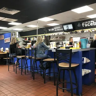 Bar style seating facing the food preparation area as you enter.