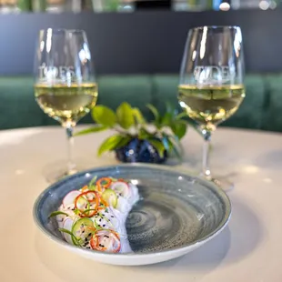 a plate of food and two glasses of wine