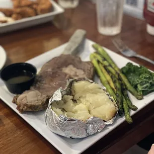 Prime rib with baked potato and asparagus