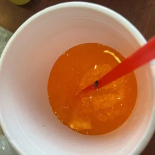 an orange liquid in a white cup