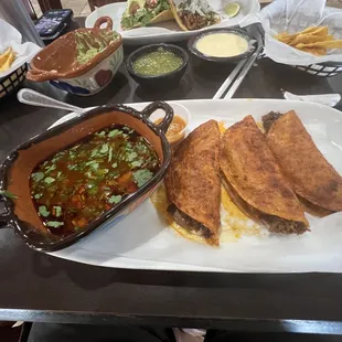 Quesabirria tacos with a side of heaven sauce.