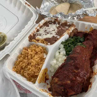 Delicious barbacoa with rice, refried beans, and tortillas.