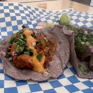 two tacos on a checkered table cloth