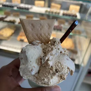 a hand holding a scoop of gelato