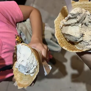 two people holding ice cream cones
