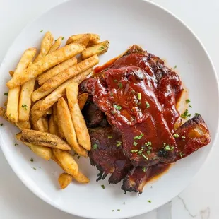 a plate of ribs and french fries