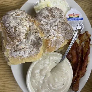 Two over medium eggs, four strips of bacon, shredded hash browns, two biscuits and gravy.