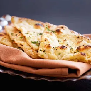 Naan...Flat bread baked in a tandoor. Choose from Classic, Chili, Garlic, Onion, Lachha Paratha, Cheese Kulch, and Peshawari varieties.