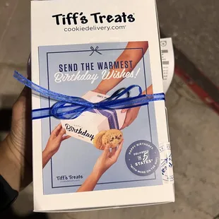 a person holding a box of cookies