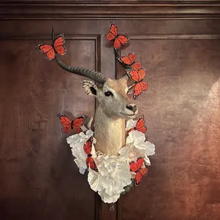 a deer head with butterflies on its antelope